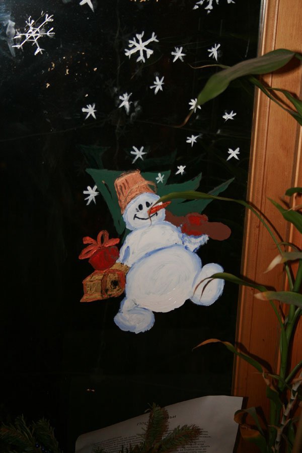 Снежинки и снеговик, нарисованные на окне