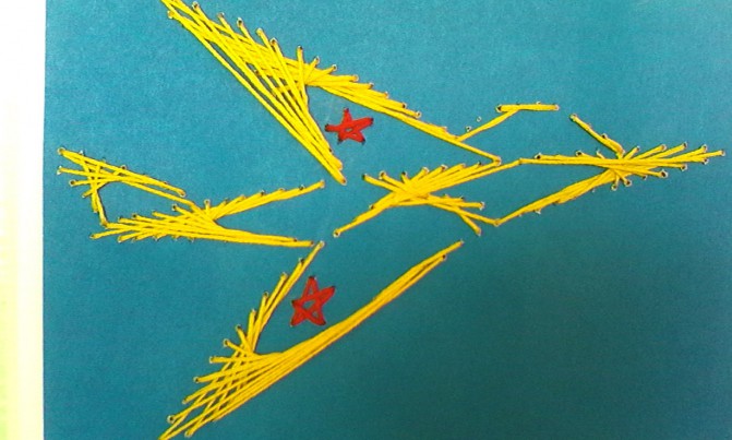 Самолёт из жёлтых ниток на синем листе